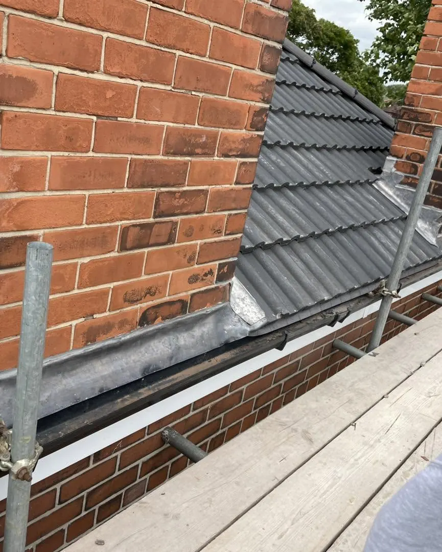 Chimney with new lead flashing in a grey tile roof