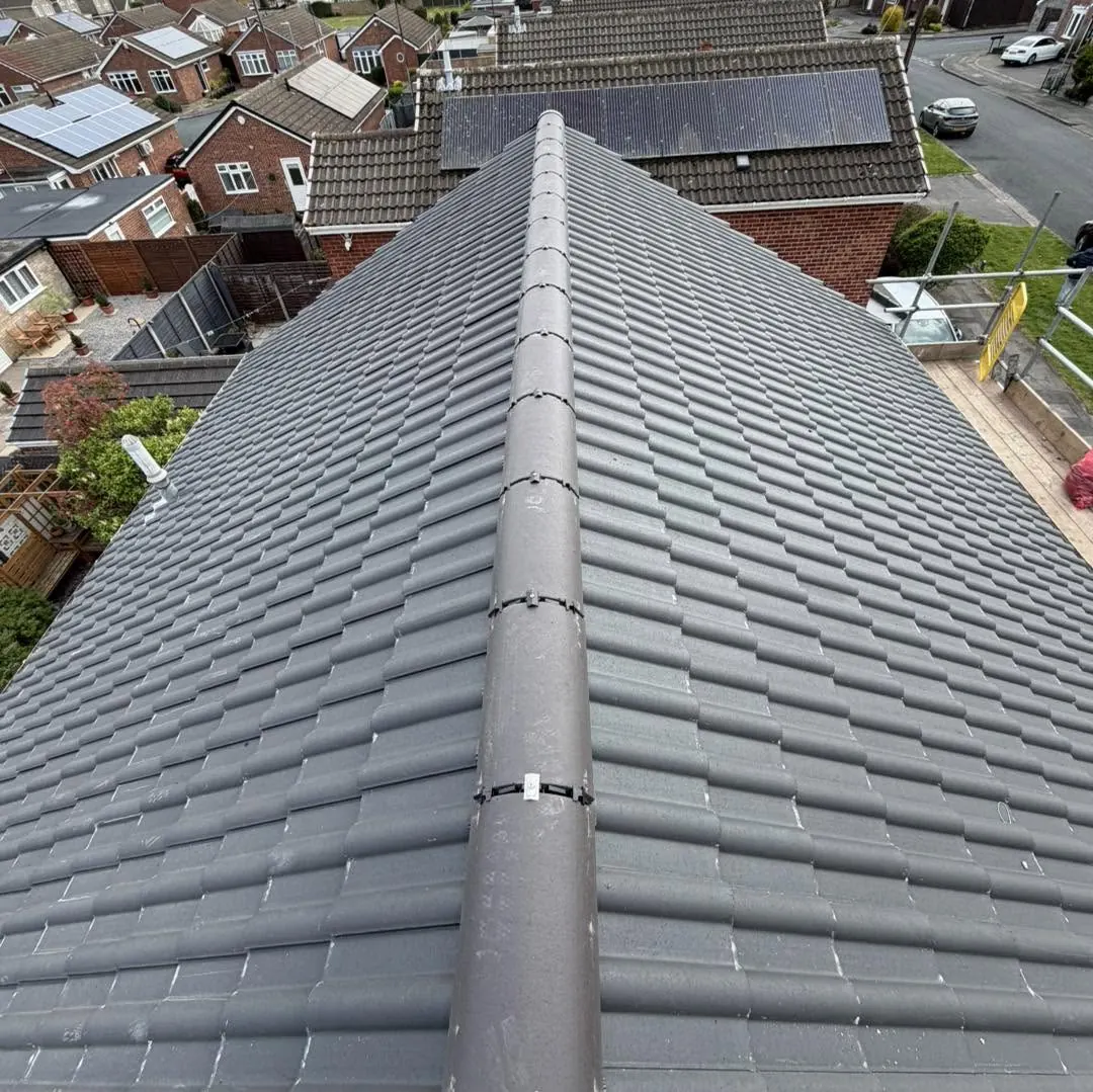 Grey tile roof with a new ridge