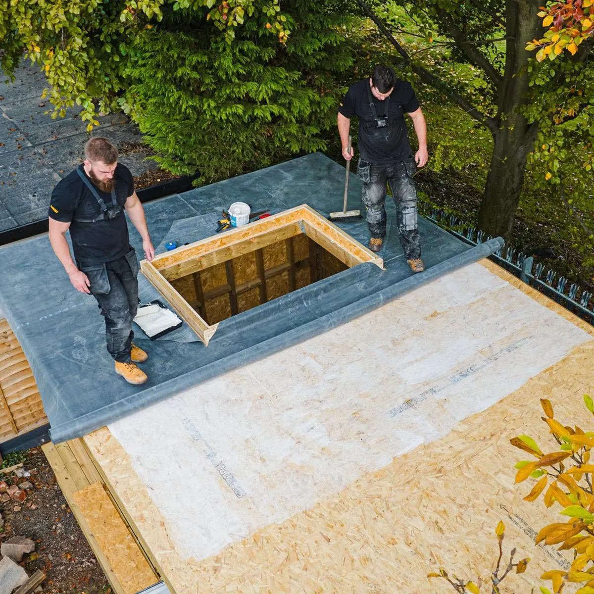 Roofers laying a new flat roof deck