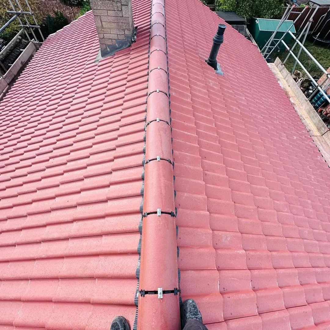 Freshly tiled red roof with a new ridge