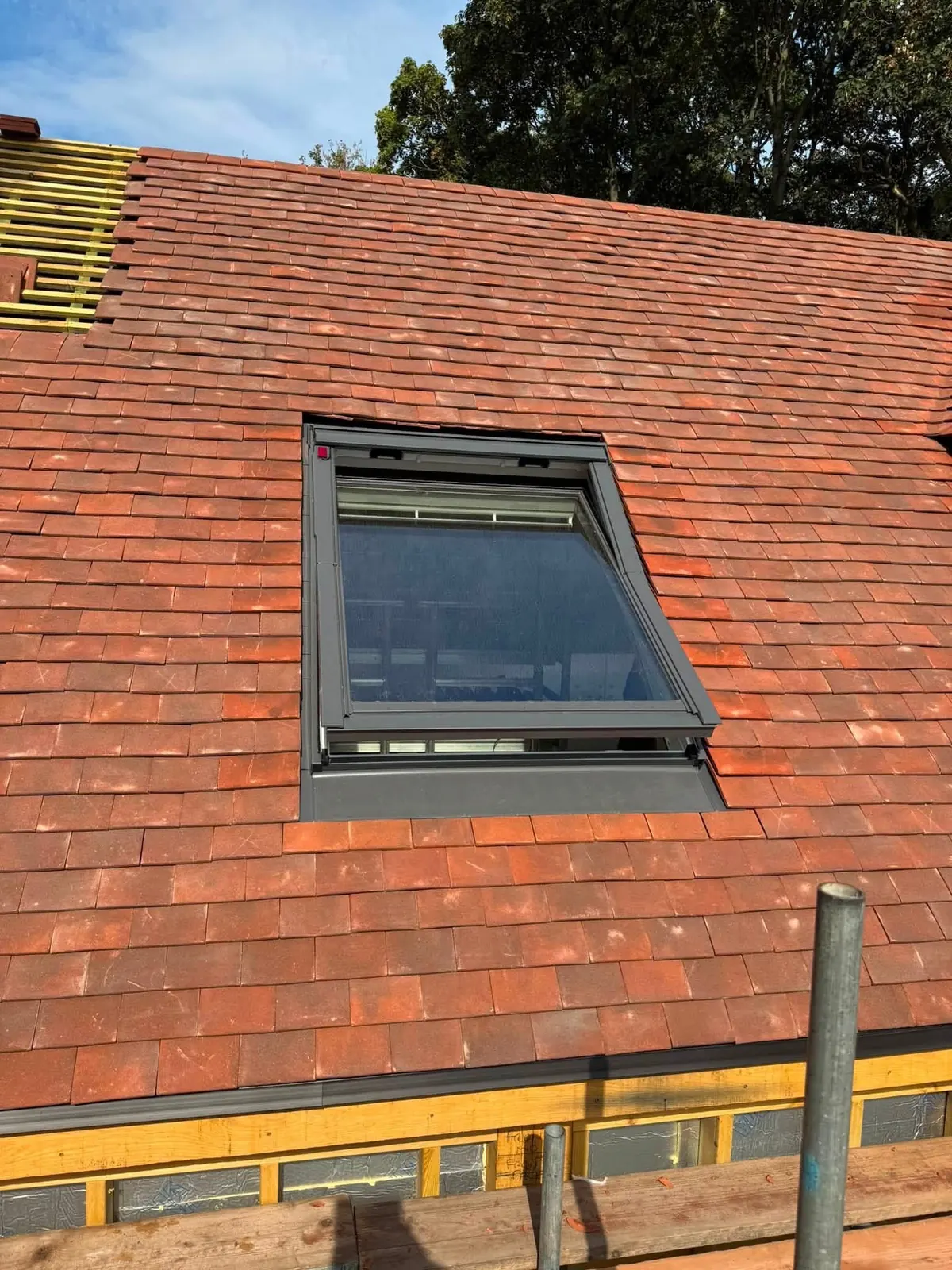 Roof window fitted in red plain tiles