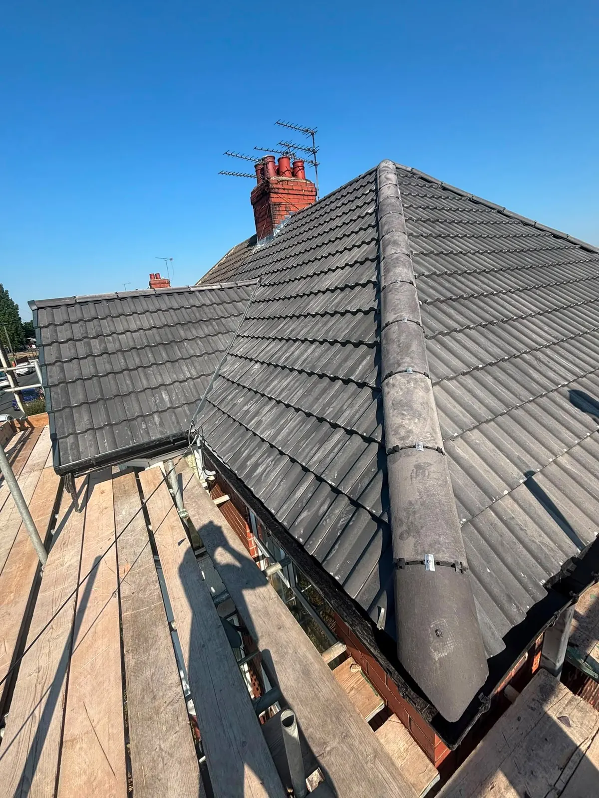 Grey tiled hip roof finished from the scaffold