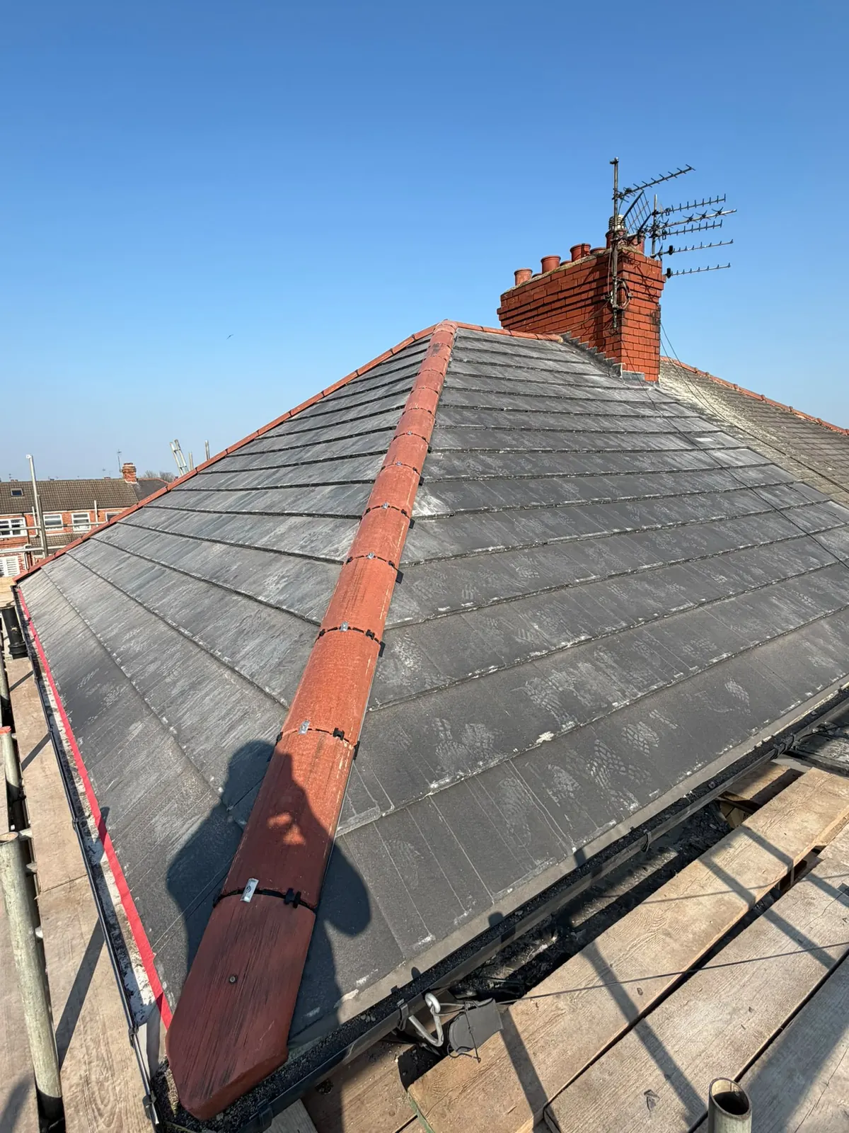 Grey tiled roof with a red ridge
