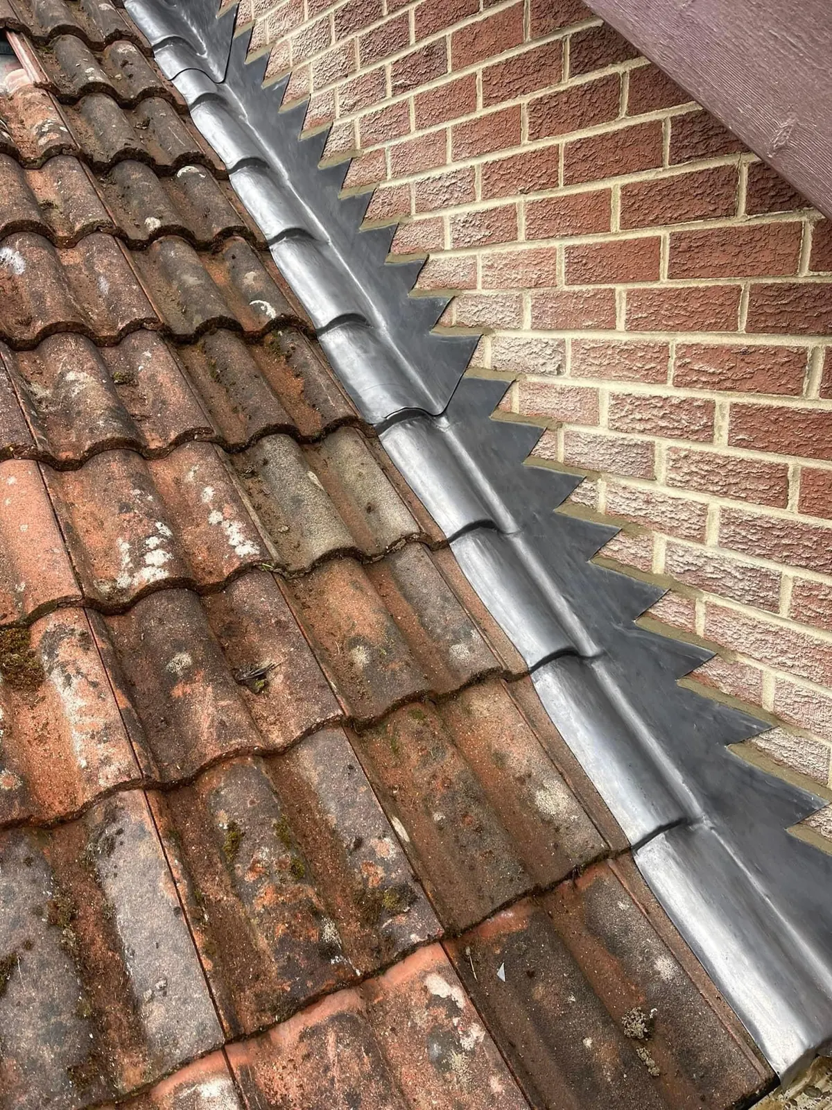 Lead flashing along a brick wall