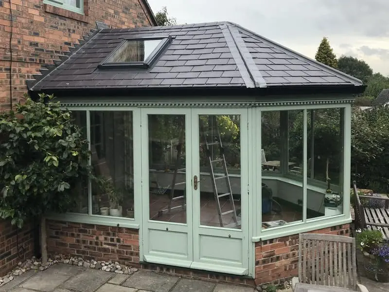 Sage green conservatory with a new tiled roof and roof window